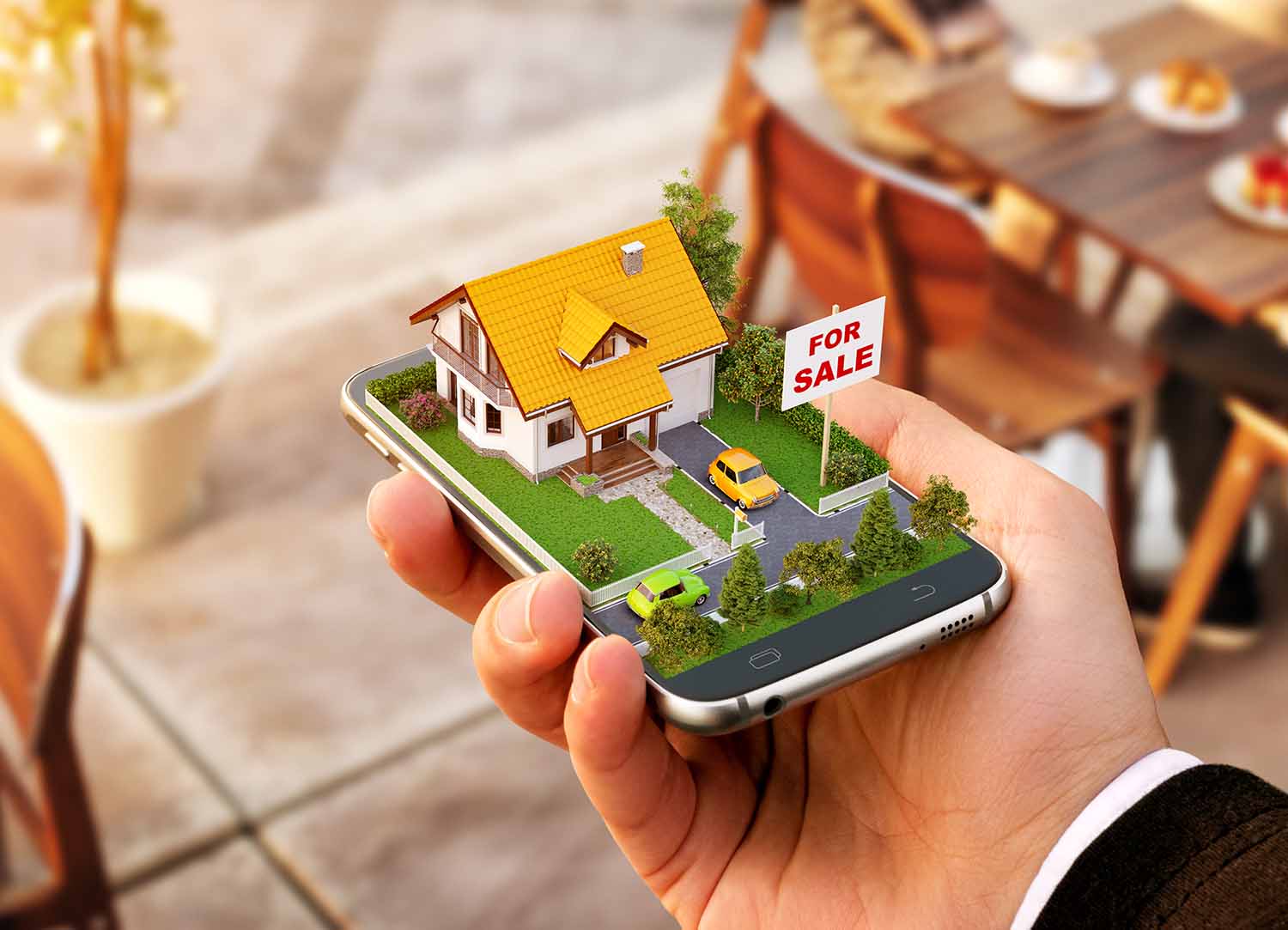 Mobiltelefon med et lite hus og hag med til salgs skilt